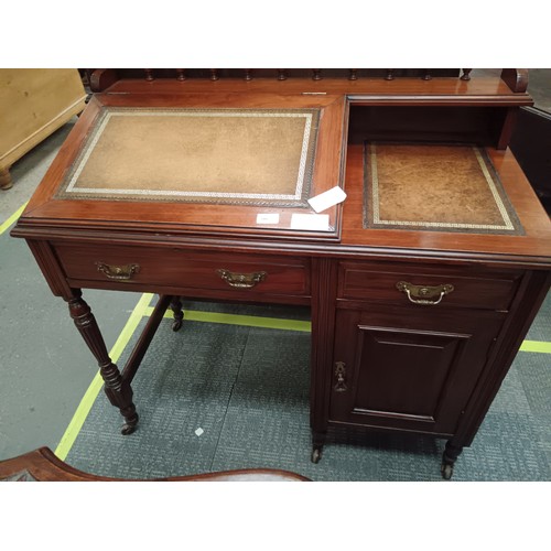 705 - A small vintage mahogany leather topped desk with lift top writing slope and side drawer and cupboar... 