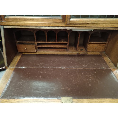 704 - A vintage oak Jacobean style 2 over 1 drawer bureau bookcase with leaded glazed upper doors