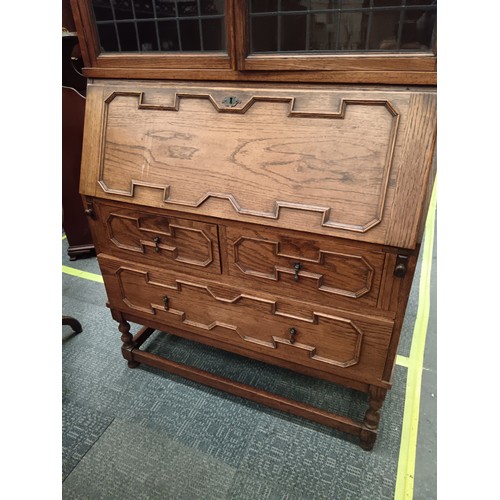 704 - A vintage oak Jacobean style 2 over 1 drawer bureau bookcase with leaded glazed upper doors