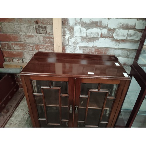 833 - A small vintage glazed mahogany 2 door cabinet