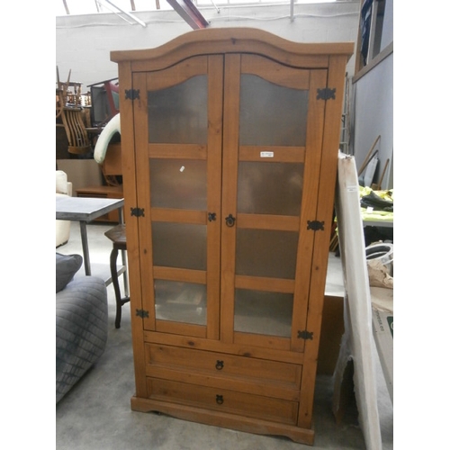 601 - A large pine cabinet with glazed doors and 2 x lower drawers - no shelves