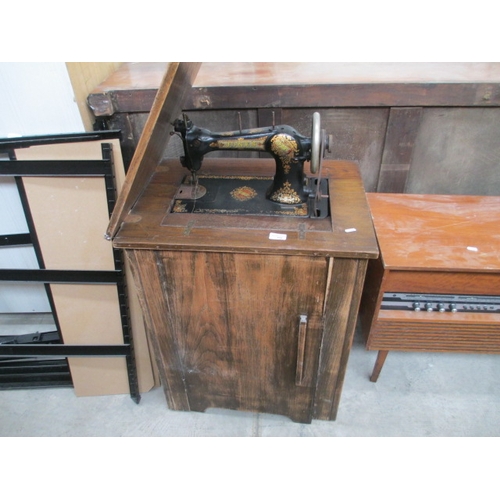 656 - A vintage JONES' treadle sewing machine in cabinet