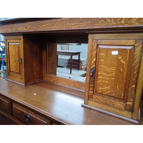 618 - A large antique solid oak mirror backed sideboard with 2 x upper cupboards and a 7 drawer base