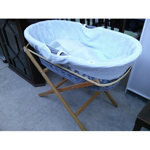 632 - A wicker crib on folding wooden stand