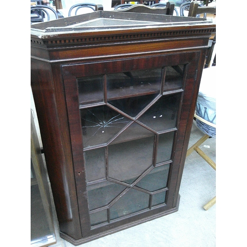 633 - An Edwardian glazed mahogany wall hanging corner cabinet - one broken pane