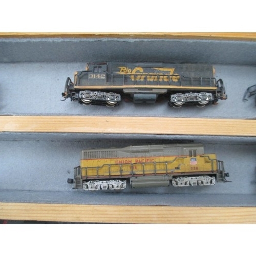 256 - Wooden display case containing miniature model rail locomotives and carriages