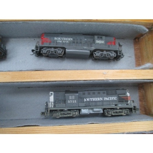 256 - Wooden display case containing miniature model rail locomotives and carriages