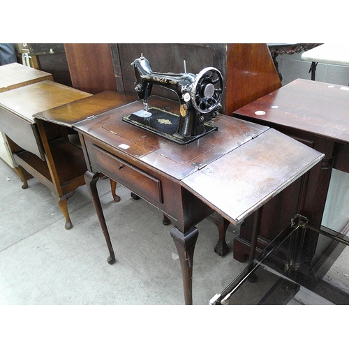 637 - A vintage SINGER sewing machine in an oak table stand