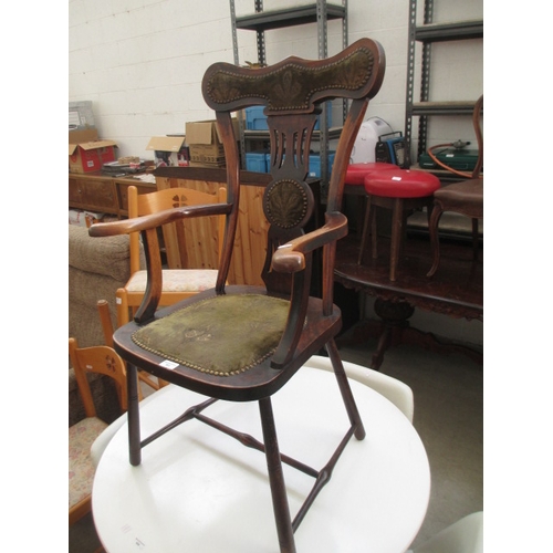 683 - An antique hardwood elbow chair with upholstered seat pads