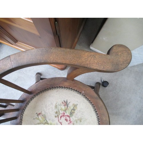 710 - A vintage wooden spindle back elbow chair with tapestry seat