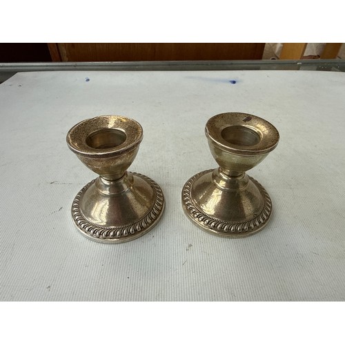 24 - Pair of sterling silver dwarf candlesticks with weighted bases, 

weight 193 grams gross