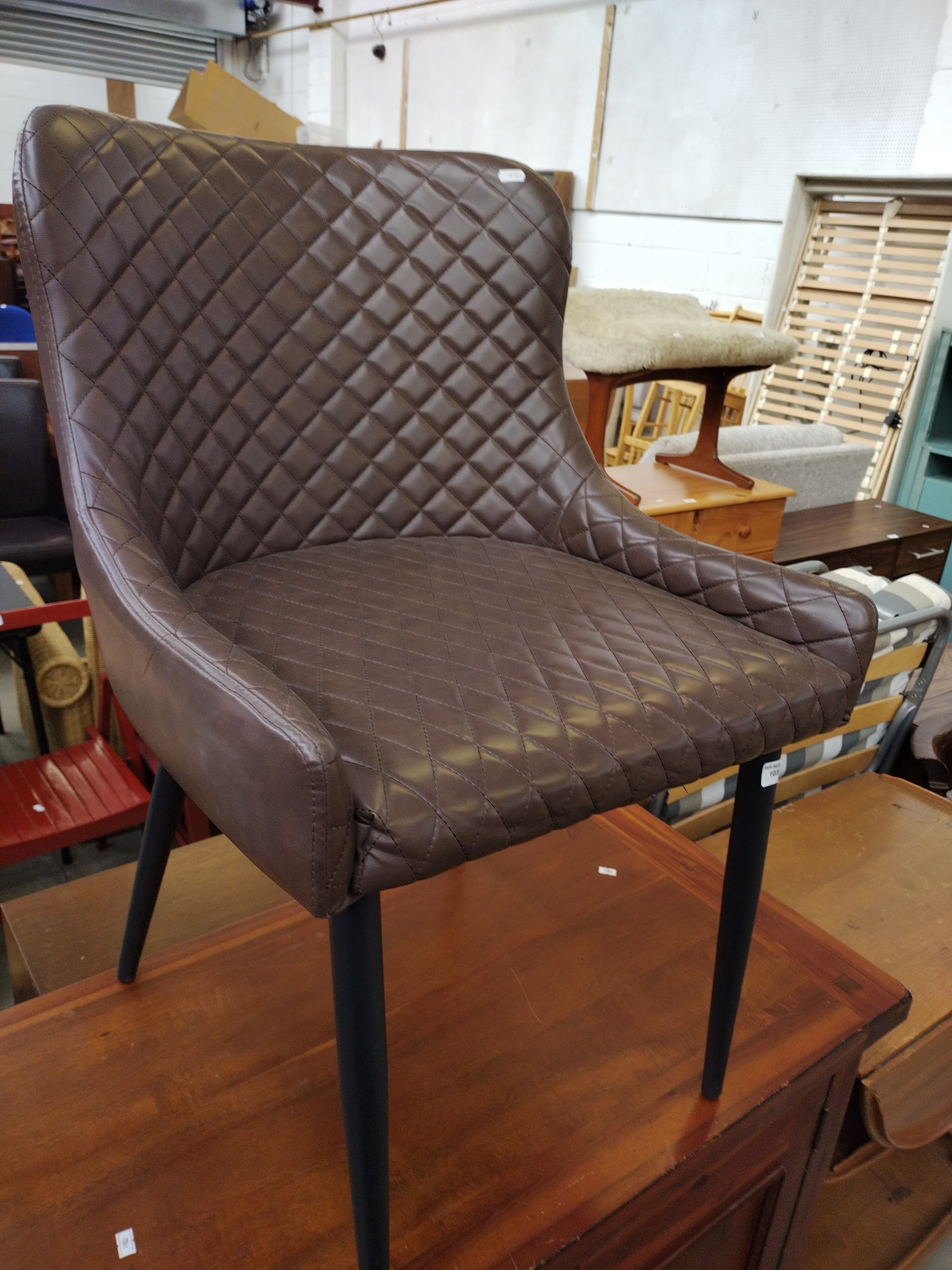 A retro padded vinyl chair on tapered legs