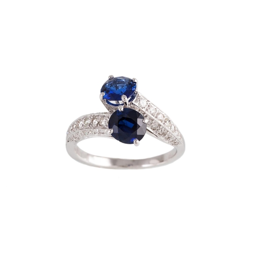 132 - A TWO STONE SAPPHIRE RING, of cross over design, the oval sapphires to diamond set shoulders, mounte... 