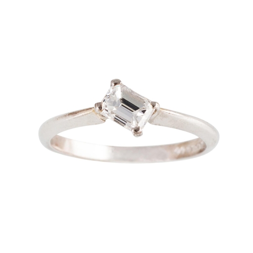 141 - A DIAMOND SOLITAIRE RING, of cross over design, set with an emerald cut diamond, mounted in platinum... 