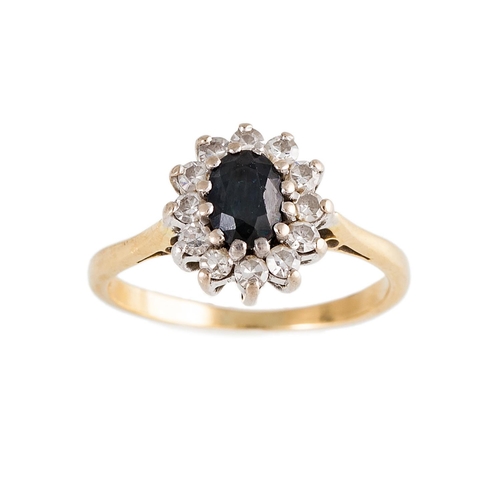 145 - A DIAMOND AND SAPPHIRE CLUSTER RING, the oval sapphire to an eight cut diamond surround, mounted in ... 