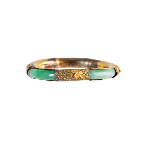 20 - A JADE BANGLE, with Chinese motifs, 14ct yellow gold mounted