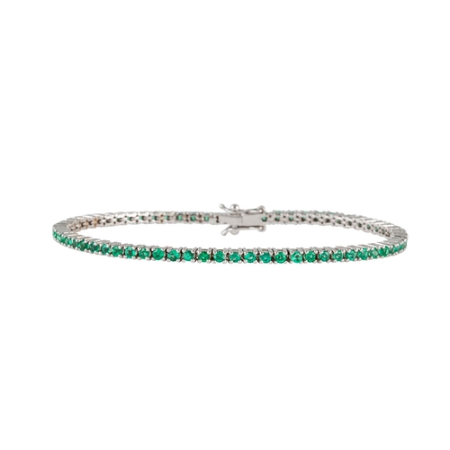 29 - AN EMERALD LINE BRACELET, the circular stones mounted in white gold. Estimated; weight of diamonds; ... 