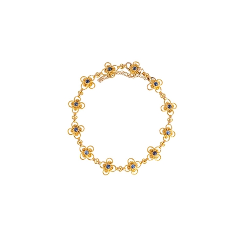 4 - A GOLD AND SAPPHIRE BRACELET, each quatrefoil openwork link set to the centre with a cabochon sapphi... 