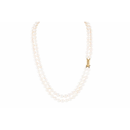 72 - A TWO STRANDED CULTURED PEARL NECKLACE, the uniform creamy pink toned pearls to a yellow gold clasp,... 