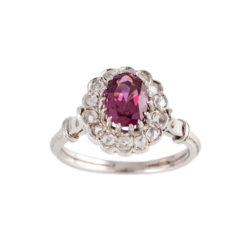 87 - A TOURMALINE AND DIAMOND RING, the oval tourmaline to a rose cut diamond surround, mounted in white ... 