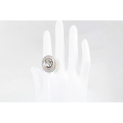 10 - A DIAMOND AND AQUAMARINE CLUSTER RING, the oval aquamarine to a two rowed circular diamond surround.... 