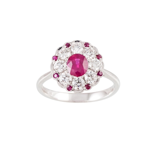 251 - A DIAMOND AND RUBY CLUSTER RING, the oval ruby to a brilliant cut diamond and ruby surround, mounted... 