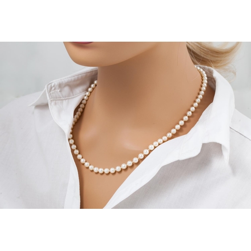 122 - A  MIKIMOTO CULTURED PEARL NECKLACE, with an 18ct yellow gold clasp, chased and engraved decoration ... 