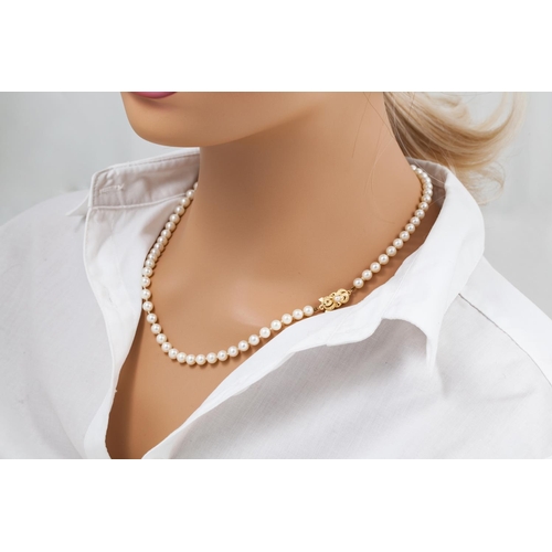 122 - A  MIKIMOTO CULTURED PEARL NECKLACE, with an 18ct yellow gold clasp, chased and engraved decoration ... 