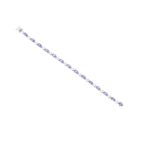 131 - A TANZANITE AND DIAMOND BRACELET, each oval tanzanite flanked by a diamond point, mounted in white g... 