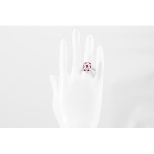 14 - A DIAMOND AND RUBY PLAQUE RING, the central collet set ruby to a diamond and ruby surround, mounted ... 