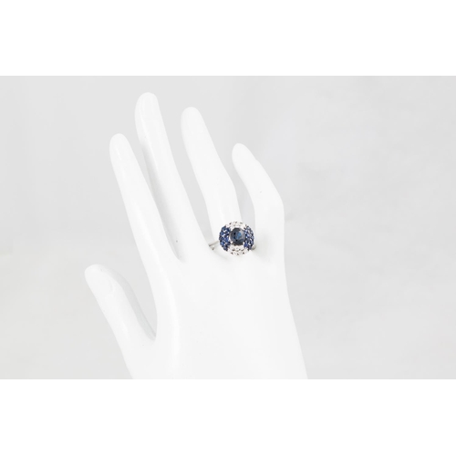 160 - A DIAMOND AND SAPPHIRE CLUSTER RING, the central sapphire to a stepped diamond and sapphire surround... 