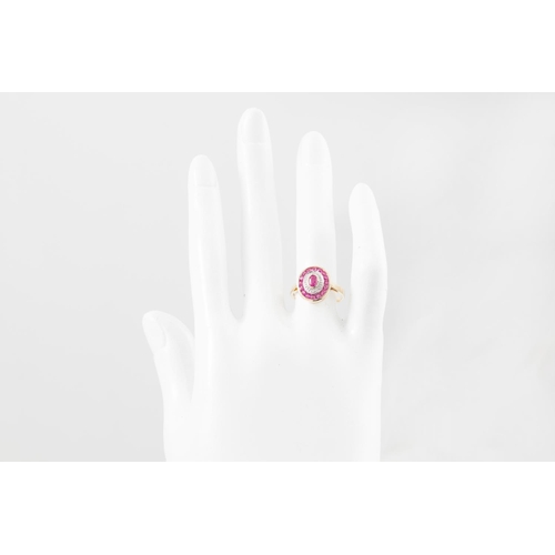 226 - A RUBY AND DIAMOND CLUSTER RING, the oval ruby to a diamond point and ruby surround, mounted in yell... 