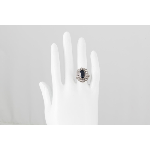 350 - AN EDWARDIAN DIAMOND AND SAPPHIRE CLUSTER RING, the oval sapphire to an old cut diamond surround, mo... 