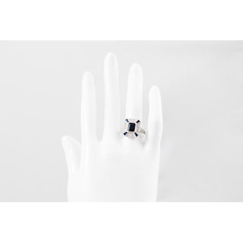 97 - A DIAMOND AND SAPPHIRE CLUSTER PLAQUE RING, the Art Deco style, the central rectangular sapphire to ... 