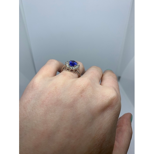 11 - A TANZANITE AND DIAMOND CLUSTER RING, the oval tanzanite to a brilliant cut diamond surround, mounte... 