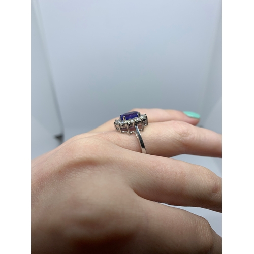 11 - A TANZANITE AND DIAMOND CLUSTER RING, the oval tanzanite to a brilliant cut diamond surround, mounte... 