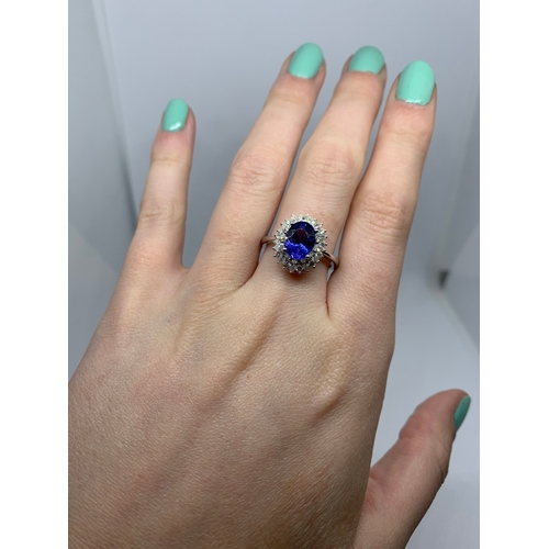 83 - A DIAMOND AND TANZANITE CLUSTER RING, the oval tanzanite to a pear and brilliant cut diamond surroun... 