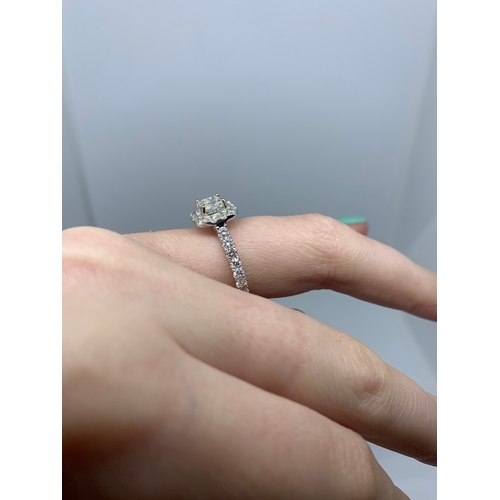 203 - A DIAMOND CLUSTER RING, the princess cut diamond to a brilliant cut diamonds surround and shoulders,... 