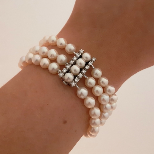 158 - A THREE ROWED PEARL BRACELET, the pearls measuring 7 mm to a brilliant cut diamond set clasp, mounte... 