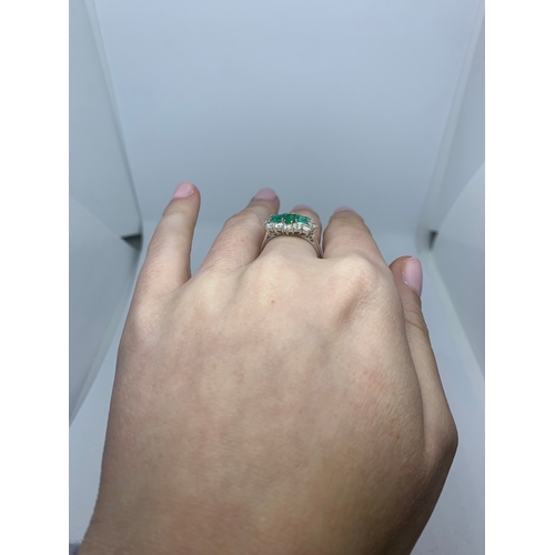 78 - A DIAMOND EMERALD CLUSTER RING, the three rectangular emeralds to a brilliant cut diamond surround, ... 