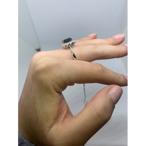 25 - A DIAMOND AND SAPPHIRE CLUSTER RING, the oval sapphire to a brilliant cut diamond surround, mounted ... 