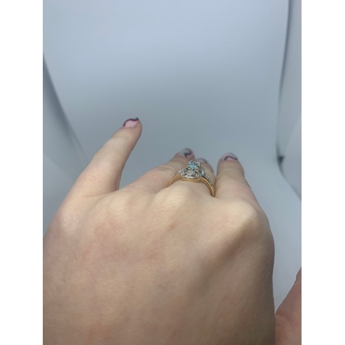 224 - AN AQUAMARINE AND DIAMOND RING, the oval aquamarine to diamond points, mounted in gold, size L.