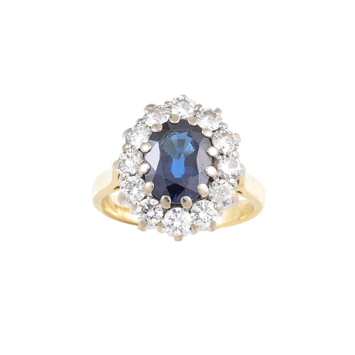 245 - A DIAMOND AND SAPPHIRE CLUSTER RING, the oval sapphire to a brilliant cut diamond surround, mounted ... 