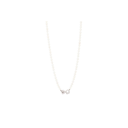 371 - A CULTURED PEARL NECKLACE, the cream toned uniform pearls to a diamond set bow clasp, 30''