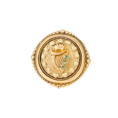 373 - AN ANTIQUE GOLD CIRCULAR BROOCH, depicting a crowned harp, set with an emerald