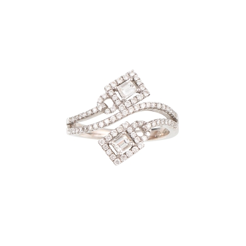 448 - A DIAMOND CLUSTER RING, of cross over design, set with rectangular and brilliant cut diamonds, mount... 