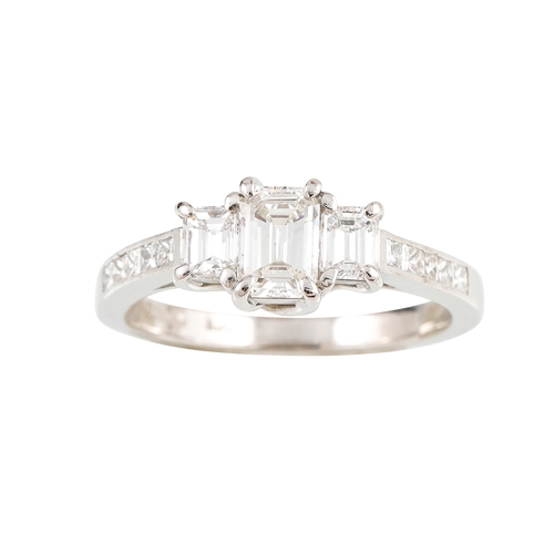 329 - A THREE STONE DIAMOND RING, comprising of three graduated emerald cut diamonds, to princess cut diam... 