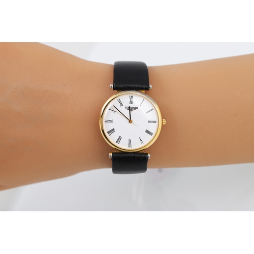 197 - A LADY'S LONGINES GOLD PLATED WRIST WATCH, white face with Roman numerals, black strap