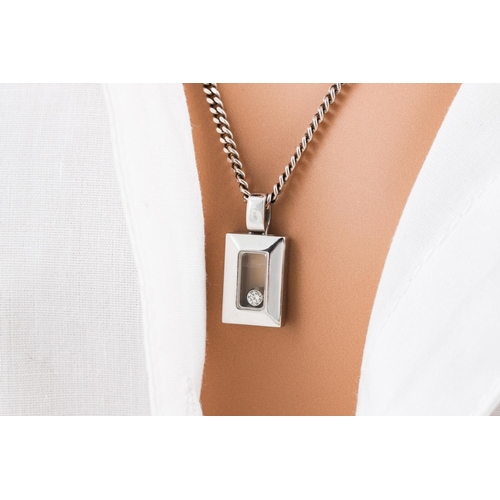 182 - A CHOPARD HAPPY DIAMOND PENDANT, the rectangular glazed compartment containing a free moving diamond... 