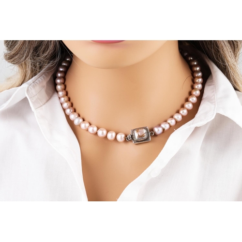 229 - A PINK CULTURED PEARL NECKLACE, with a pearl set silver clasp